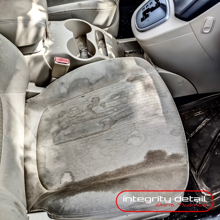 Cloth vehicle seat with heavy stains before interior detailing