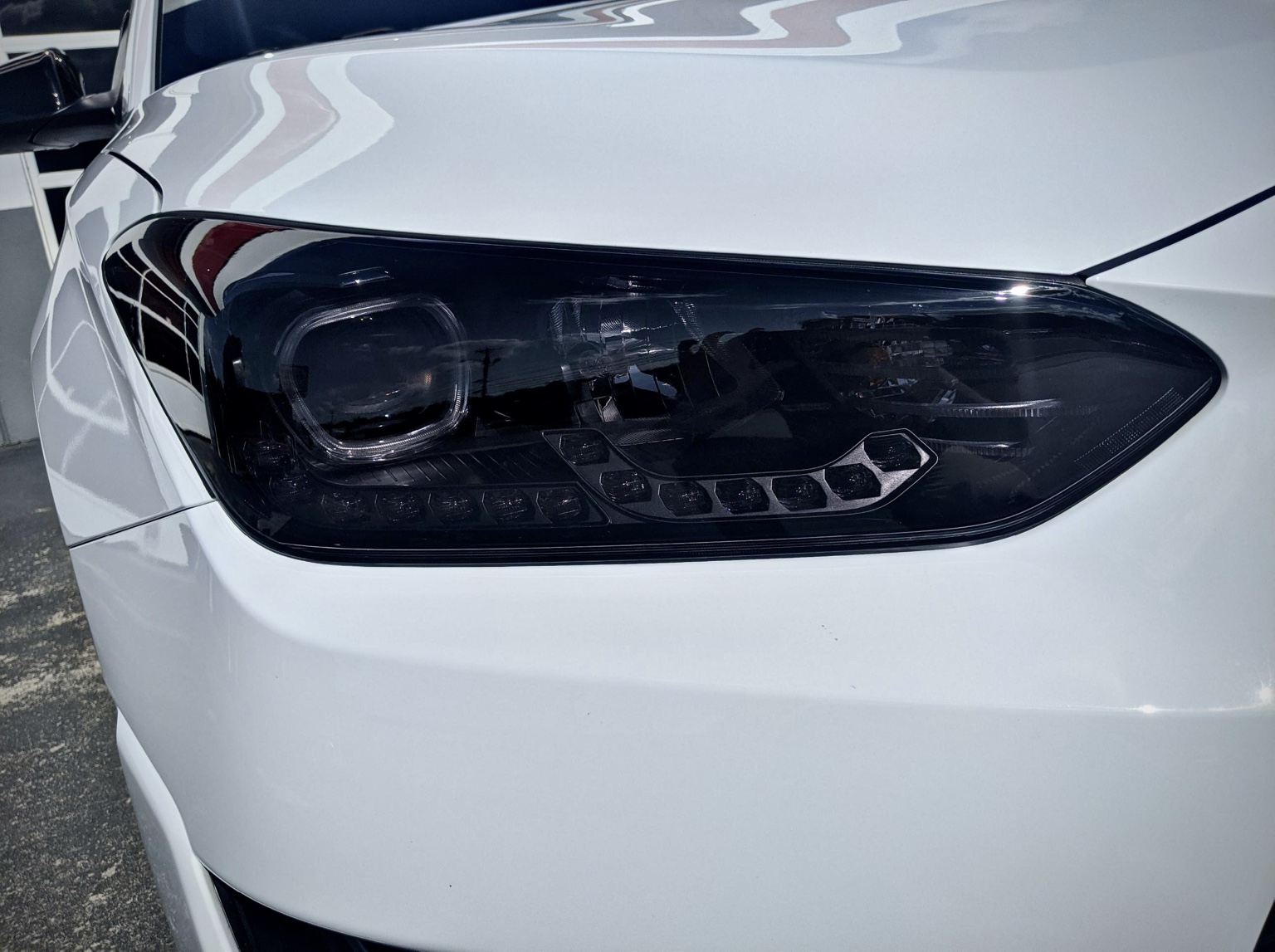 White Hyundai headlight with dark tinted protective film installed by Integrity Detail