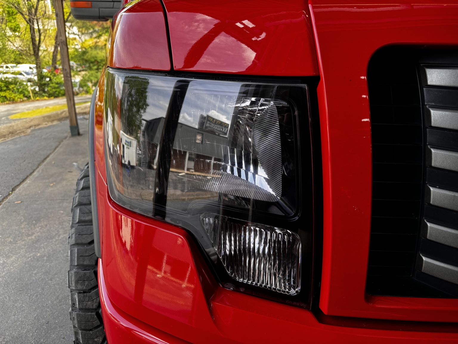 Headlight on a red truck with light tinted protective film