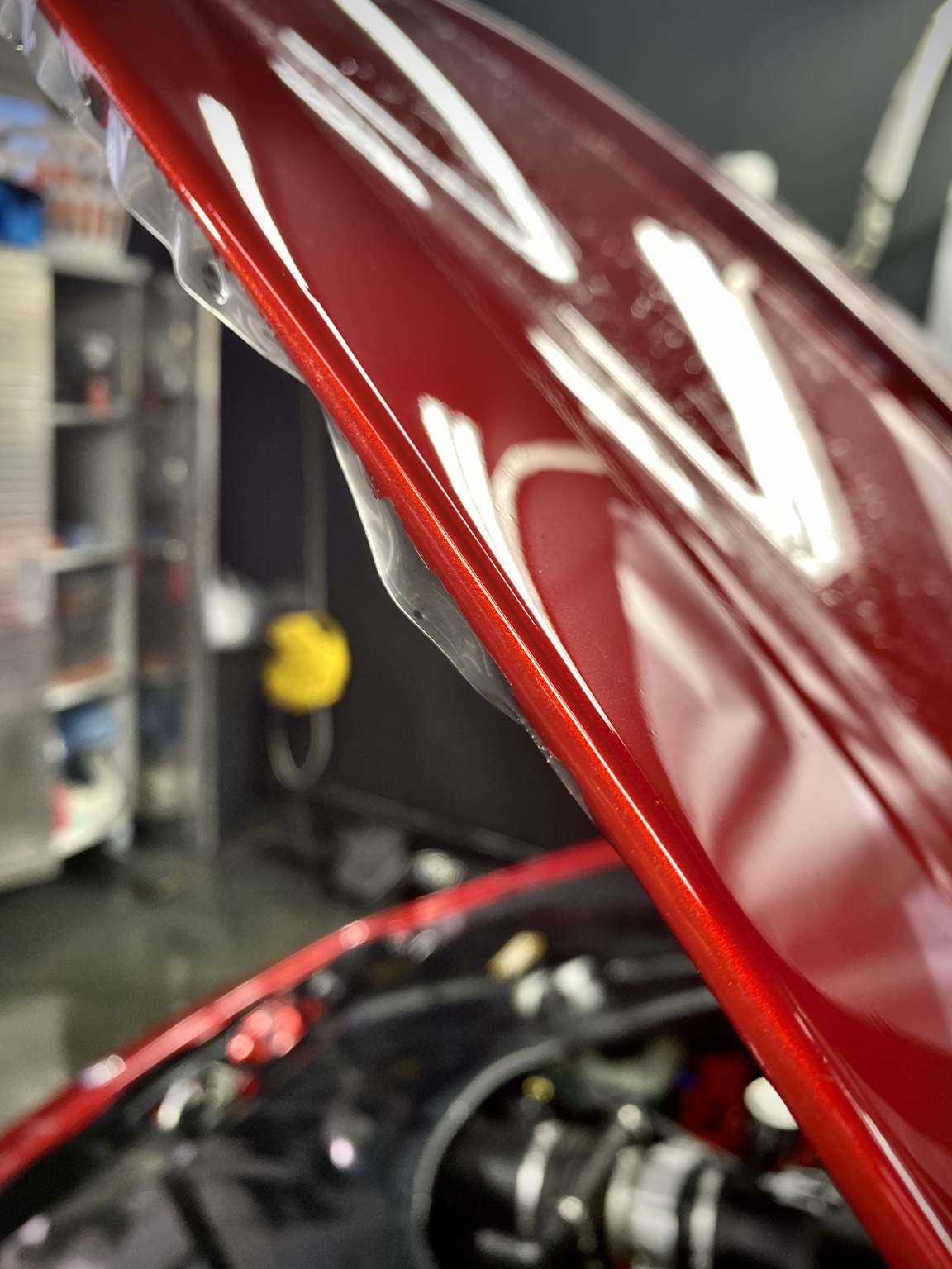 Close-up of paint protection film coverage on a red Maserati