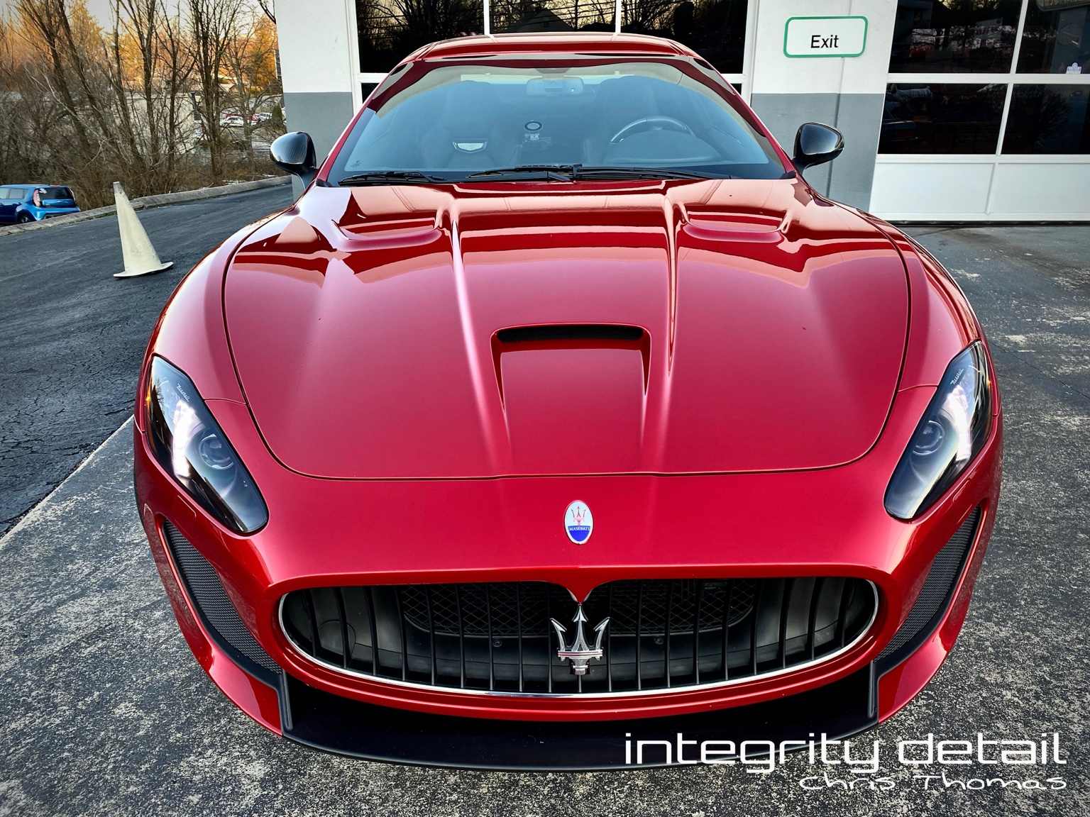Finished red Maserati after paint protection film installation by Integrity Detail, photographed outside the shop with the Integrity Detail watermark